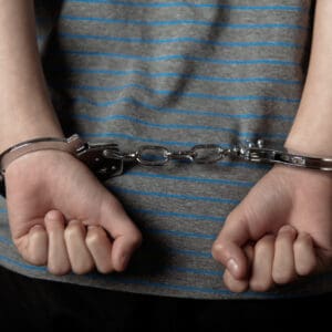 Child in handcuffs symbolizing Ian Brady early start in crime