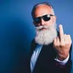 old man flipping off camera, representing history of the middle finger