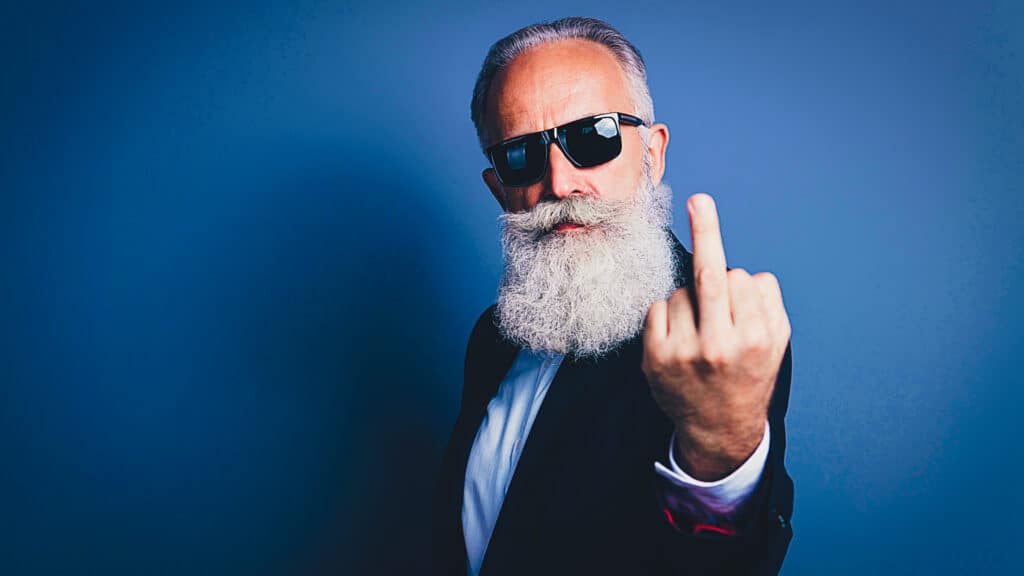 old man flipping off camera, representing history of the middle finger