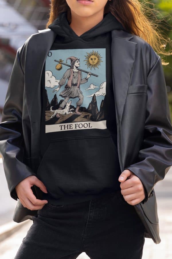 alternative non-binary person wearing the fool tarot hoodie under leather jacket