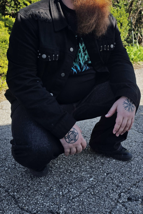bearded punk man kneeling in black skater jeans