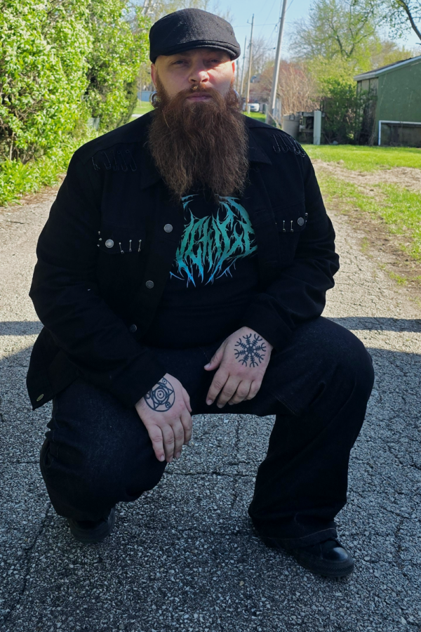 pank man with beard wearing black jeans and kneeling