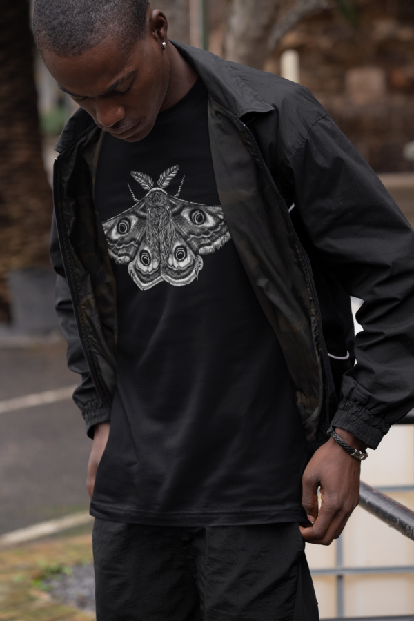 alternative man in all black outfit with moth graphic tee