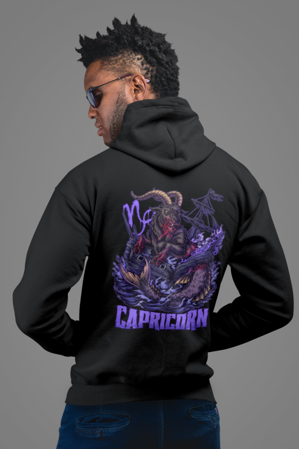 grunge model posing in capricorn astrology hoodie with horror graphic on back