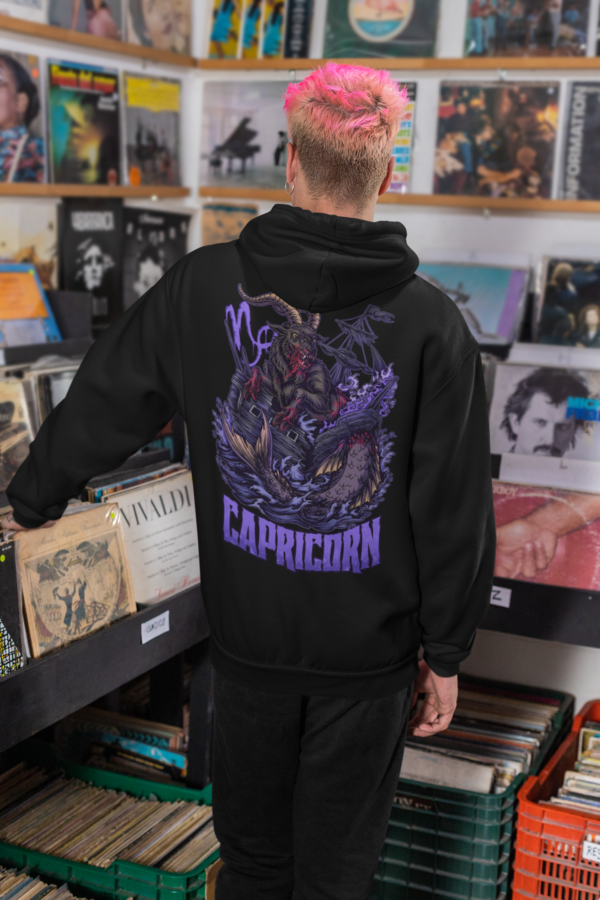 punk man perusing record store while wearing alt style capricorn zodiac hoodie