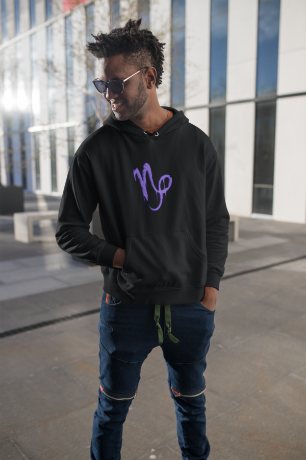 punk man wearing dark astrology hoodie with capricorn design on front and back