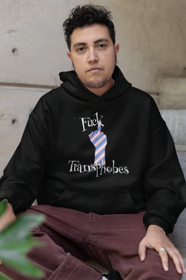 trans man looking at camera while wearing punk style fuck transphobes hoodie
